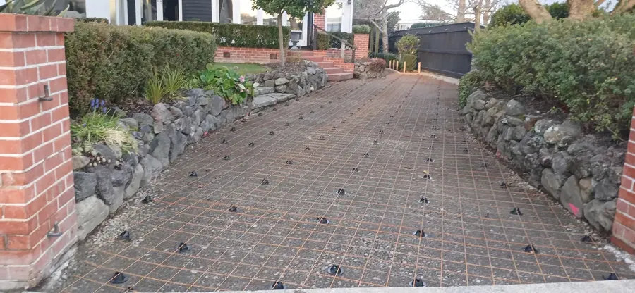 Reinforcing mesh and boxing set out for a concrete driveway between brick gate pillars in Palmerston North